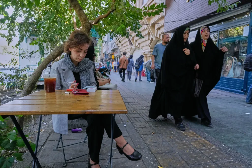 A women sits in the al fresco dining area of a cafe