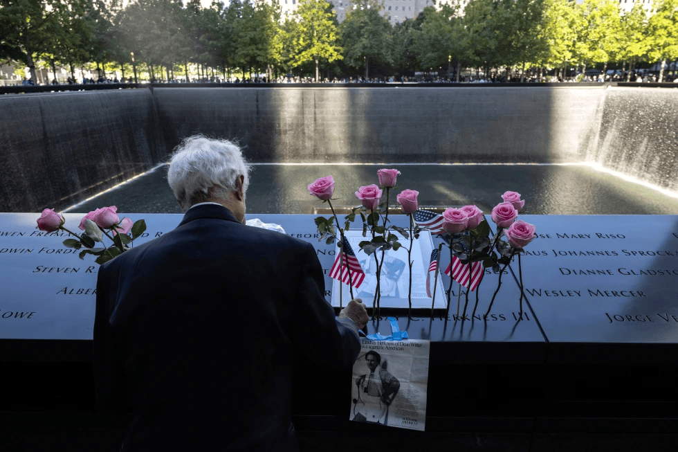 Hagi Abucar places flowers for his former coworker Lindsey Herkness on the south reflecting pool during the 9/11 Memorial ceremony on the 23rd anniversary of the Sept. 11, 2001 attacks, Sept. 11, 2024, in New York. 
