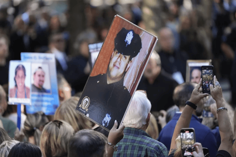 A woman holds up a photo of a New York City Police officer during the 9/11 Memorial ceremony on the 23rd anniversary of the Sept. 11, 2001 attacks, Sept. 11, 2024, in New York
