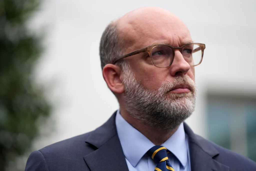 Russell Vought, Office of Management and Budget director, listens as he addresses members of the media outside the West Wing at the White House in Washington, Monday, Sept. 29, 2025, in Washington