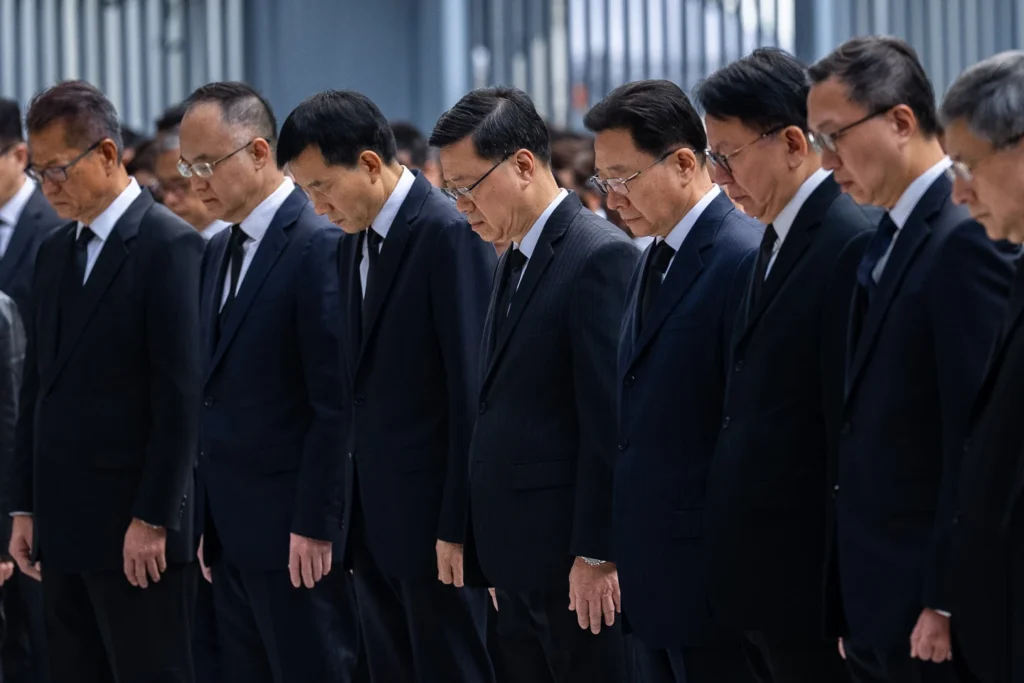 Hong Kong Chief Executive John Lee and other officers observe a moment of silence for the victims of the deadly fire