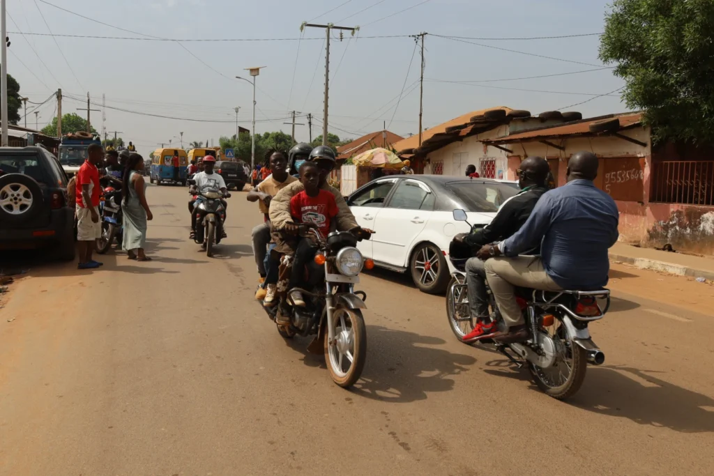 People ride on motorcycle taxis on streets in Bissau, Guinea-Bissau