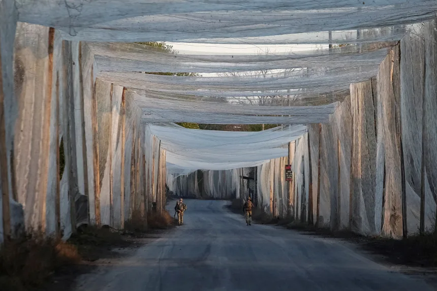 Ukrainian servicemen walk along a road covered with anti-drone nets in the frontline town of Kostiantynivka, in Ukraine's Donetsk region, on November 3.