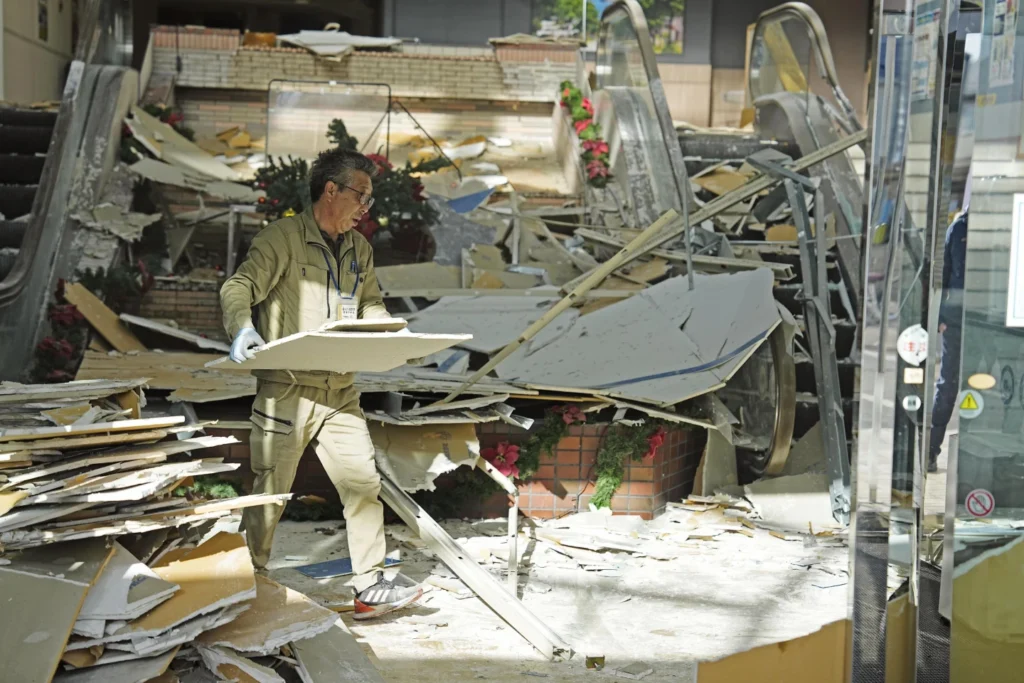 A man clears the debris from a powerful earthquake at a commerical facility in Hachinohe, Aomori prefecture, northern Japan