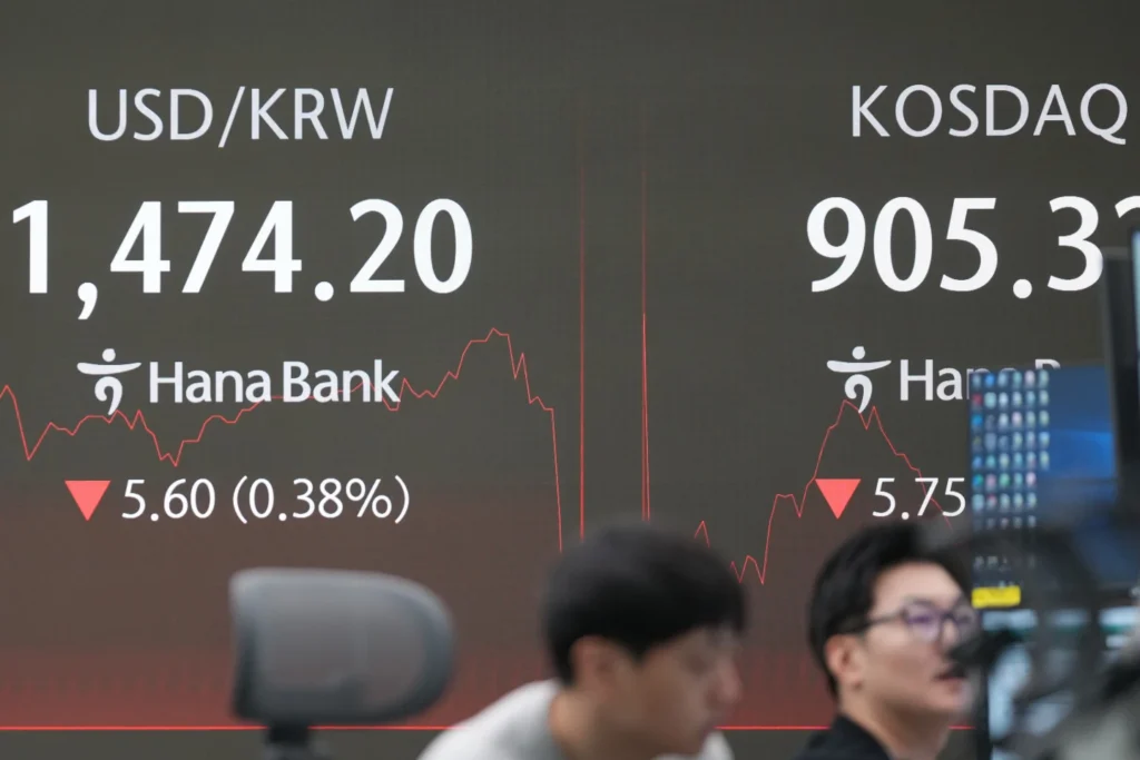 Dealers work near the screens showing the foreign exchange stock rate between U.S. dollar and South Korean won and the Korean Securities Dealers Automated Quotations (KOSDAQ) at a dealing room of the Hana Bank in Seoul, South Korea