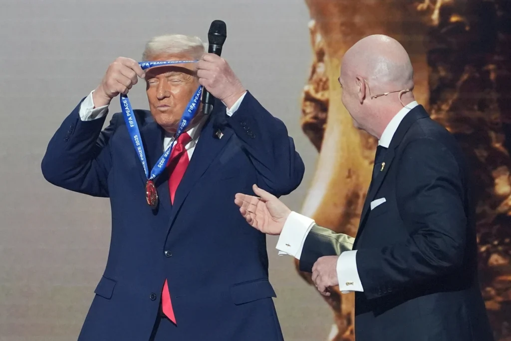 President Donald Trump is presented with the inaugural FIFA Peace Prize by FIFA President Gianni Infantino during the 2026 FIFA World Cup draw at the Kennedy Center in Washington
